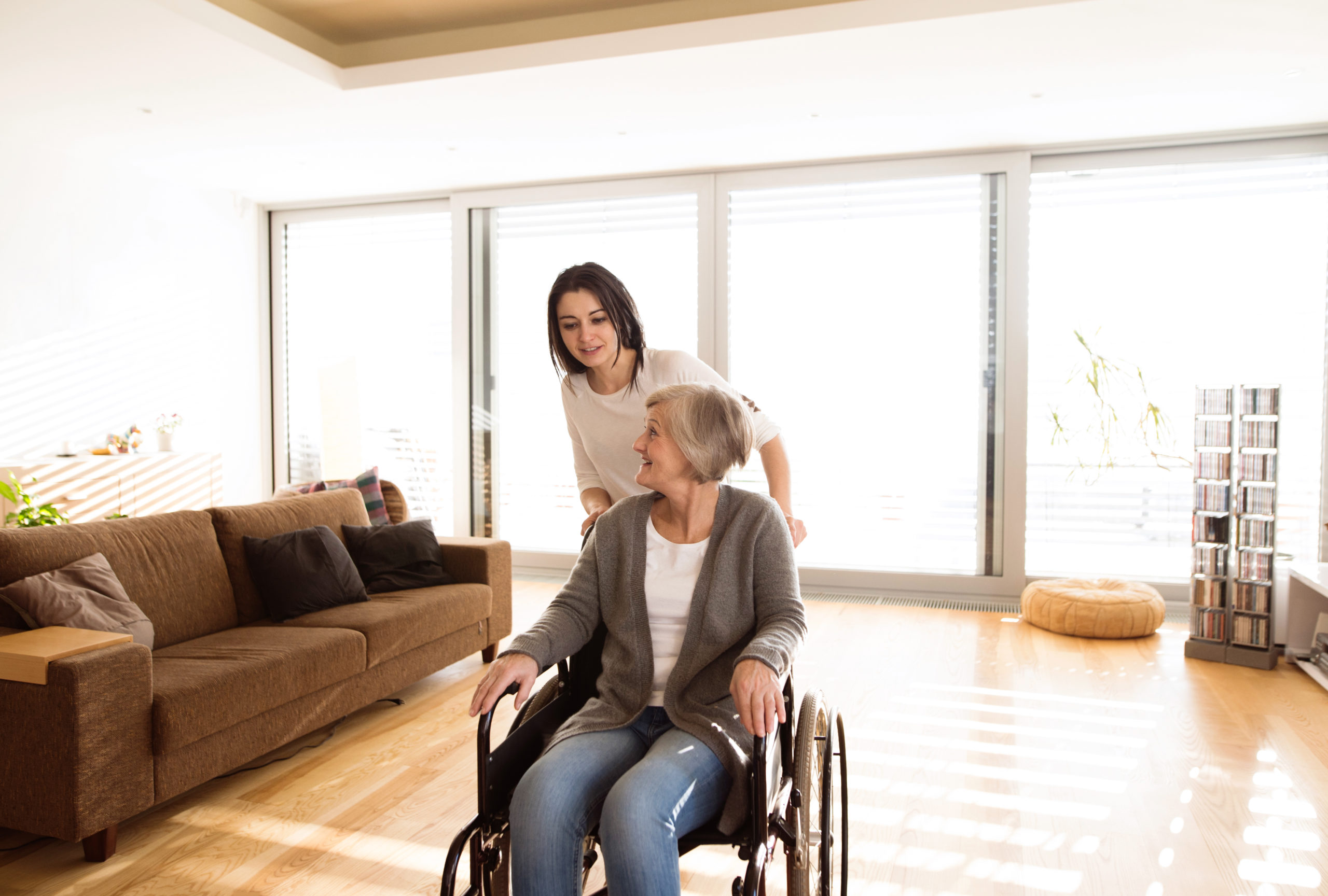 graphicstock disabled senior woman in wheelchair at home in her living room with her young daughter caring for her_Su eWr_8GZ scaled 1