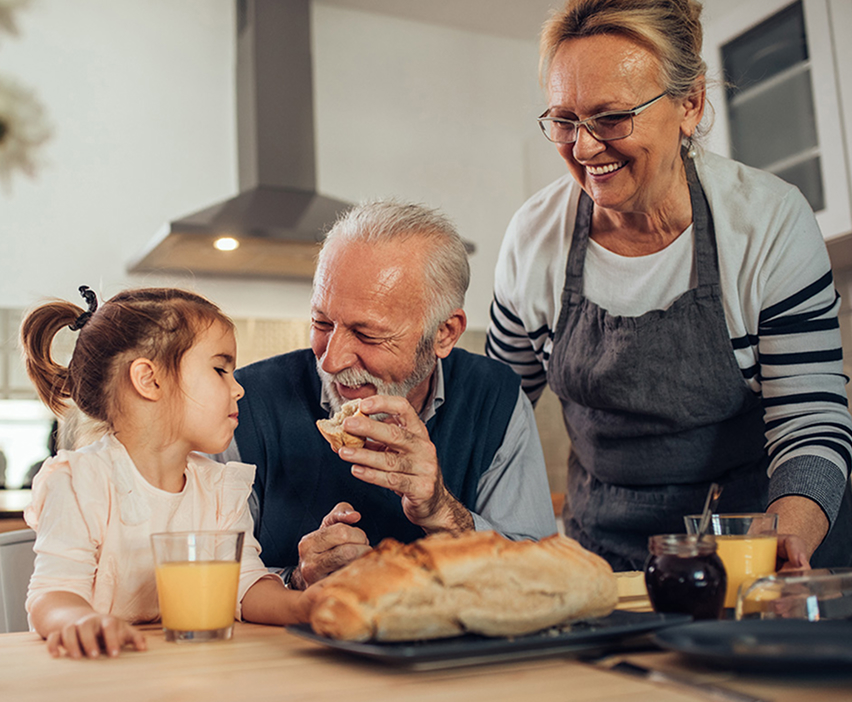 Grandparents having breakfast with their granddaughter